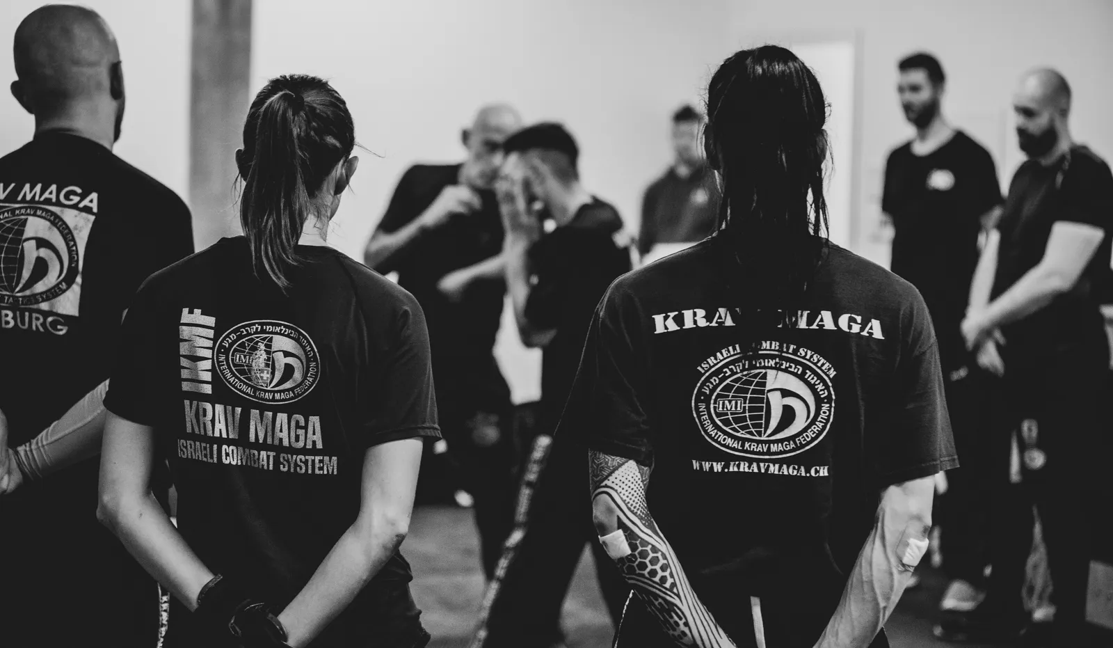 Krav-Maga-Gruppe verfolgt eine Technik-Demonstration im Trainingsraum